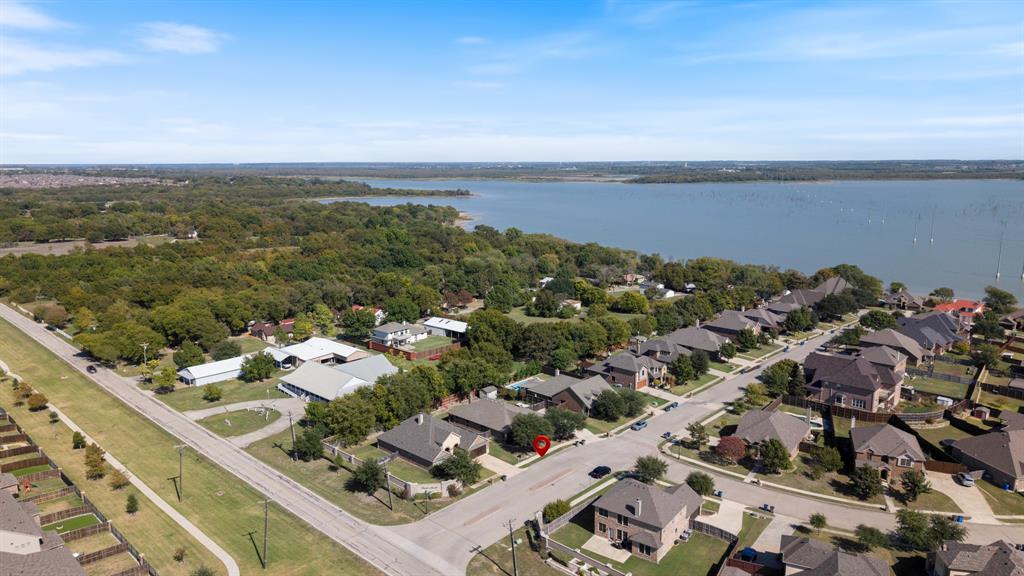Aerial perspective showcasing residential positioning near a large lake, mature tree-lined surroundings, and established street infrastructure