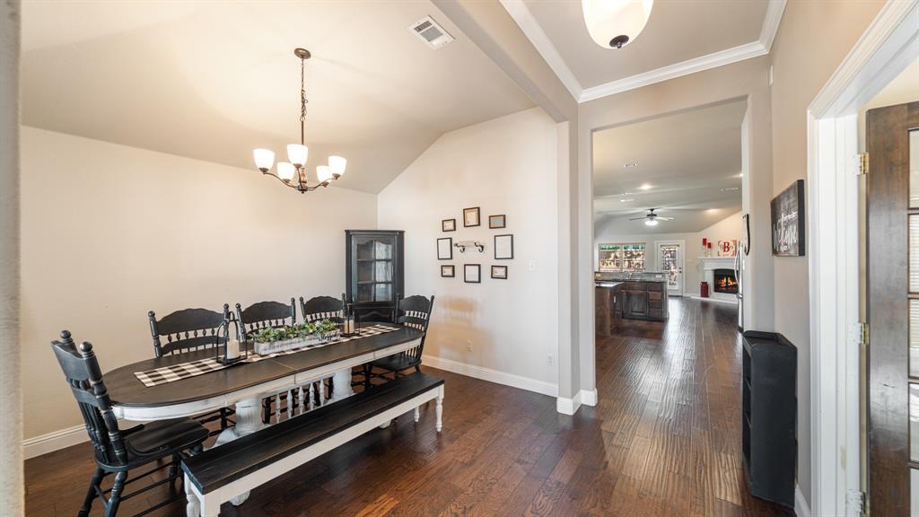 Vaulted ceilings with crown molding, wood-finish flooring, and a multi-light chandelier Vaulted ceilings with crown molding, wood-finish flooring, and a multi-light chandelier