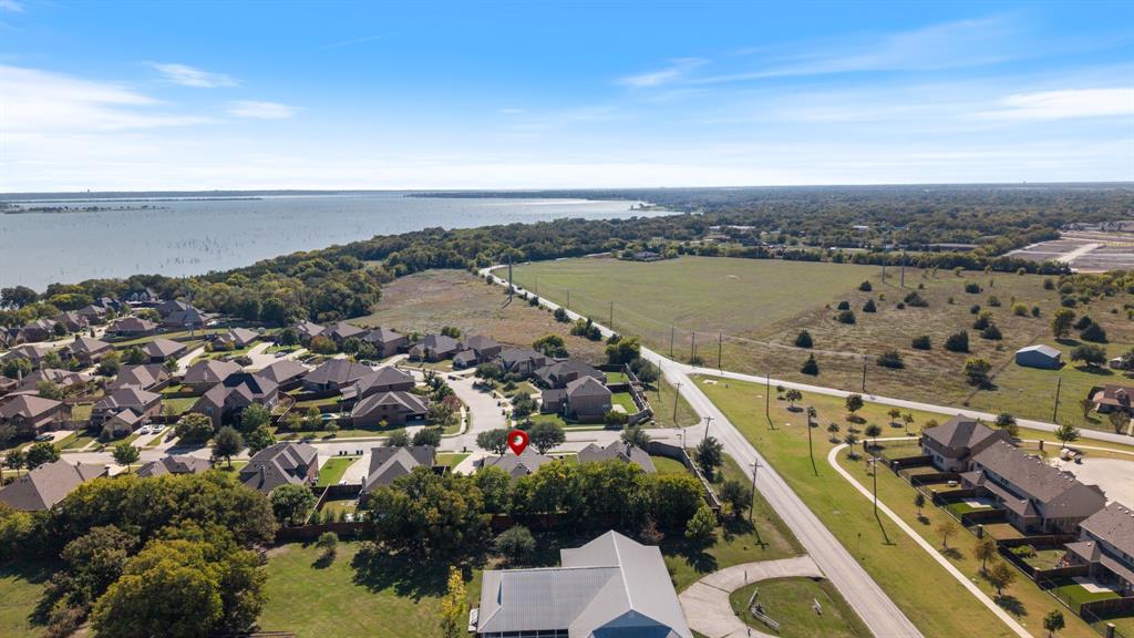 Aerial perspective featuring proximity to a large body of water, extensive open green space, and mature tree canopy