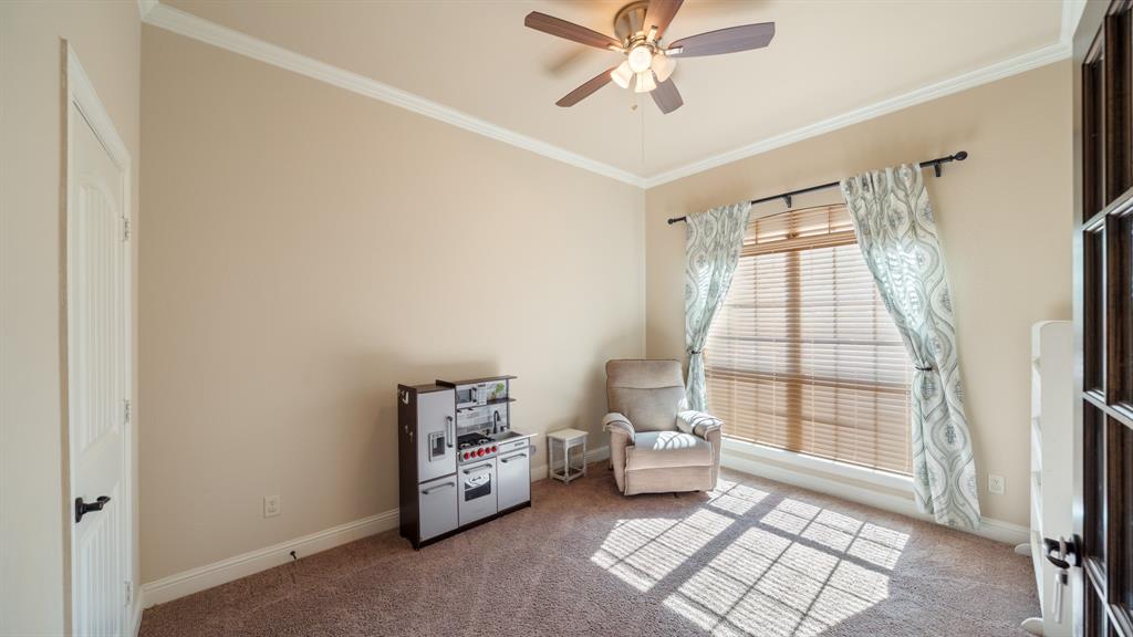 Room featuring neutral paint, wall-to-wall carpeting, ceiling fan with light kit, crown molding, and a single-pane window with blinds