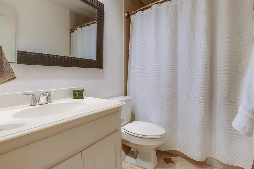 Bathroom featuring a white vanity with integrated sink, chrome faucet, and a framed wall mirror