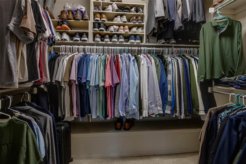 Custom closet system featuring multiple hanging rods, integrated shelving, and shoe storage