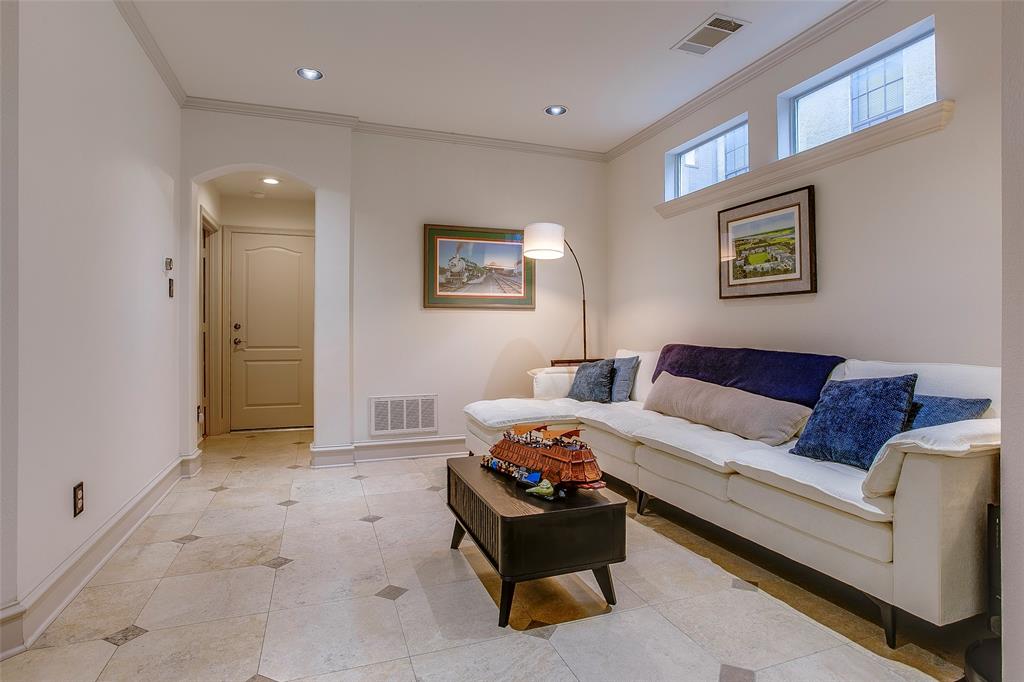Living area featuring tile flooring with decorative inserts, recessed lighting, and crown molding