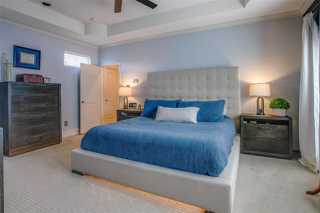 Bedroom featuring a tray ceiling with recessed lighting and a ceiling fan