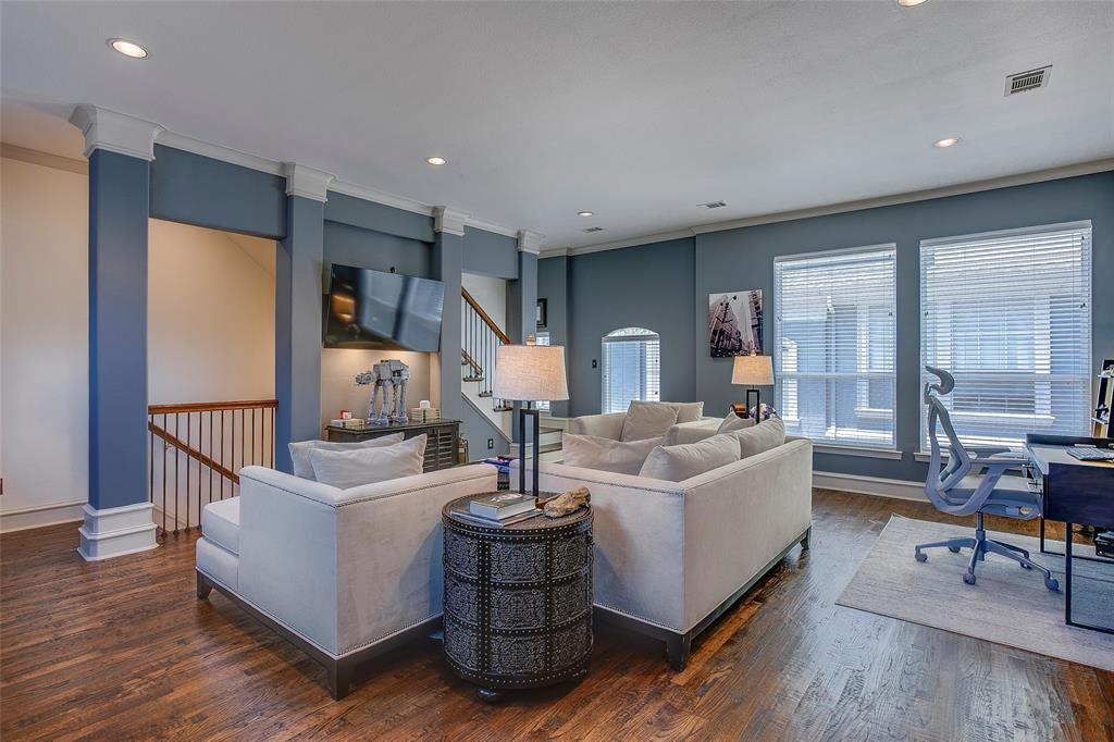 Spacious living area featuring wood-finish flooring and recessed lighting