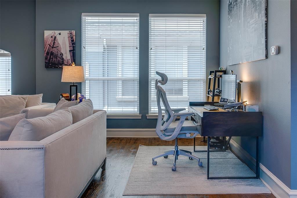 Interior space featuring wood-finish flooring, two large windows with blinds, and painted walls