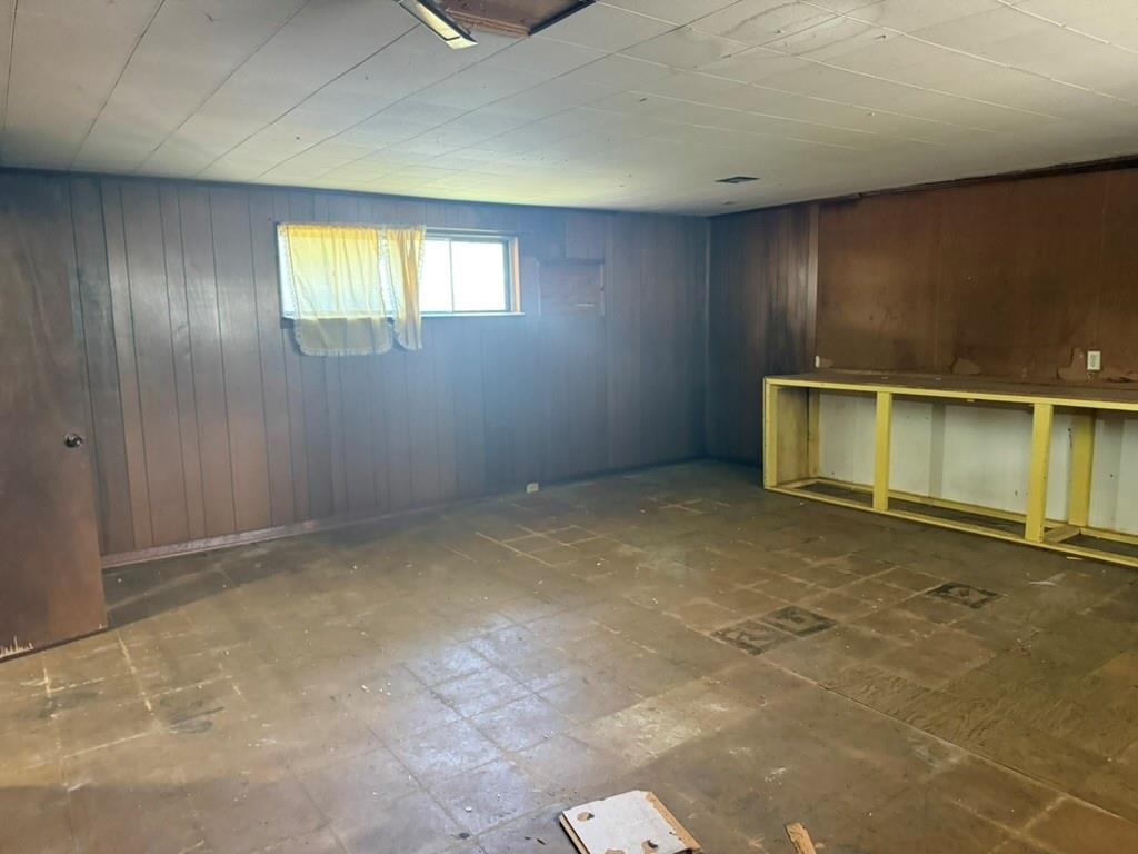 Interior space featuring paneled wood walls, paneled ceiling, and a built-in wooden frame workstation