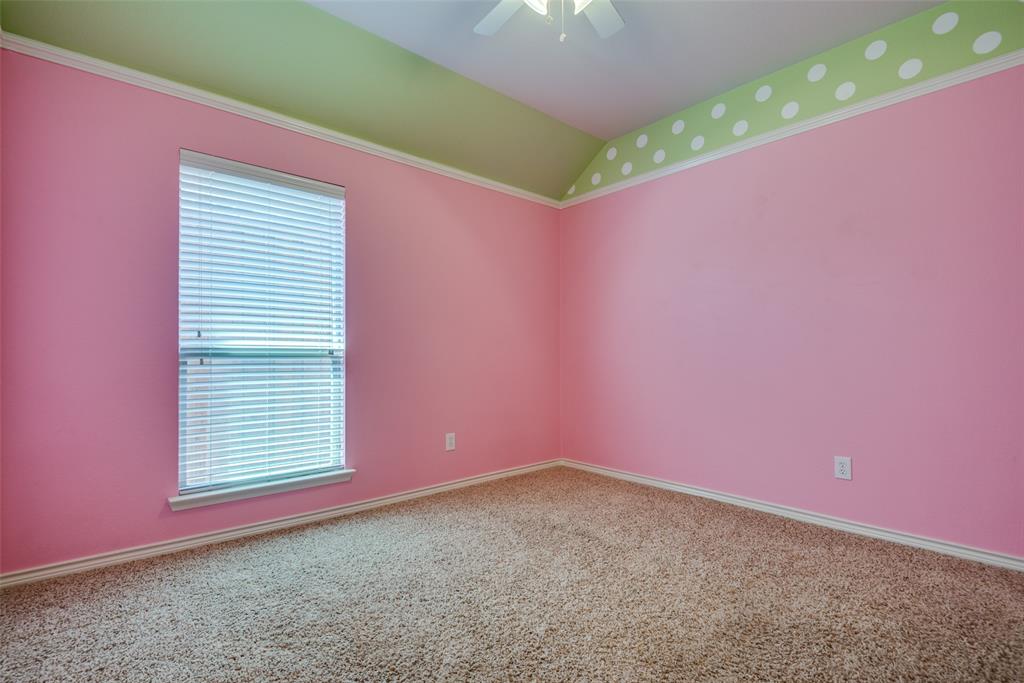 Spare room with a ceiling fan, carpet flooring, and vaulted ceiling