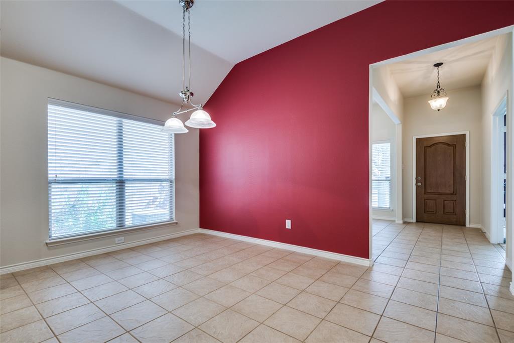 Unfurnished room featuring light tile patterned floors, baseboards, an inviting chandelier, and vaulted ceiling