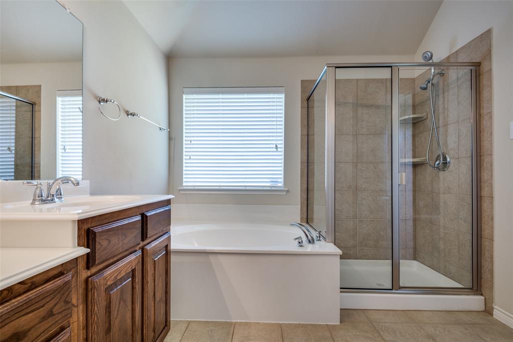 Bathroom featuring tile patterned flooring, a bath, a stall shower, and vanity