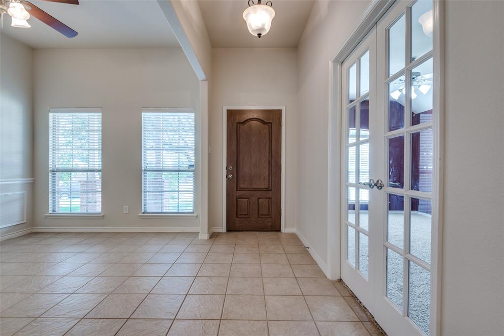 Entryway with light tile patterned floors, baseboards, and a ceiling fan