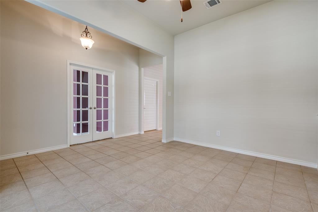 Empty room featuring french doors, baseboards, visible vents, and ceiling fan