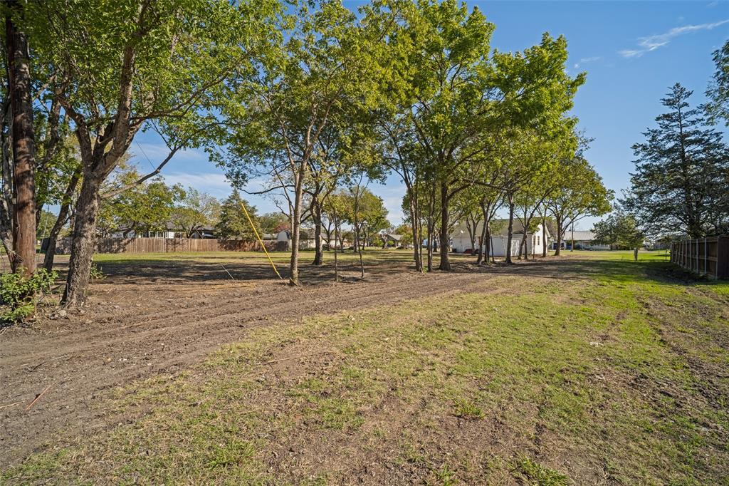 Expansive level lot featuring mature trees, partial fencing, and open green space