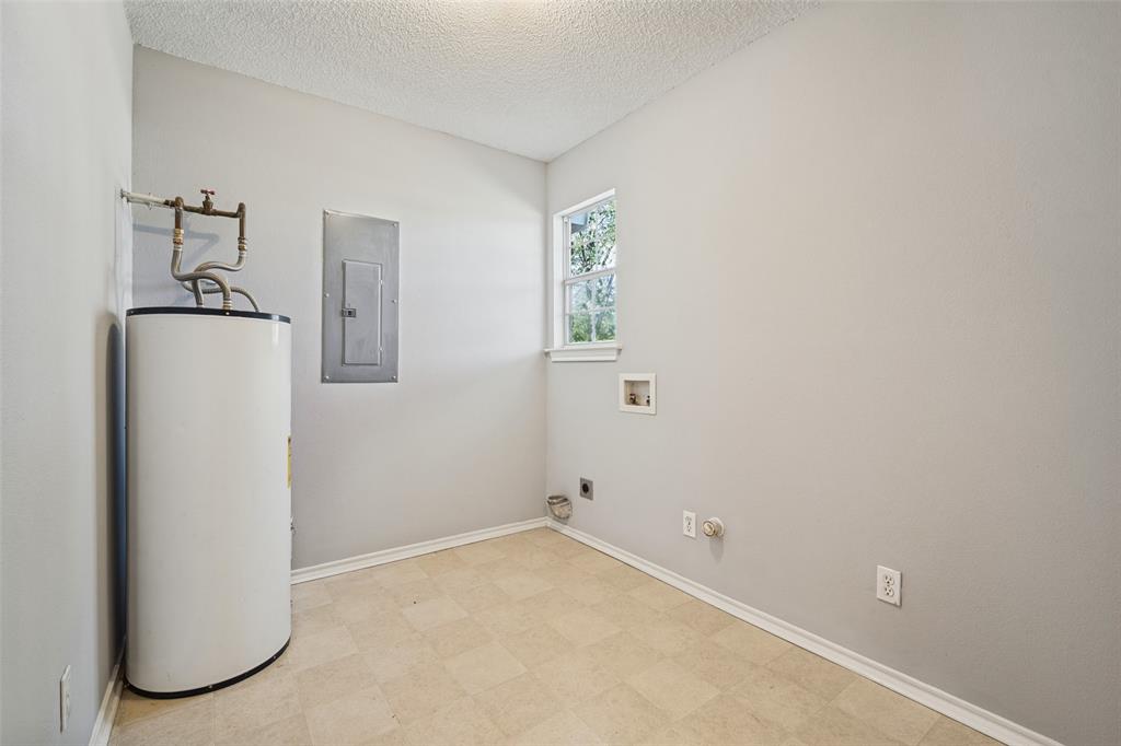 Utility room featuring an electric water heater, integrated electrical panel, wall-mounted window, and dedicated washer and dryer hookups