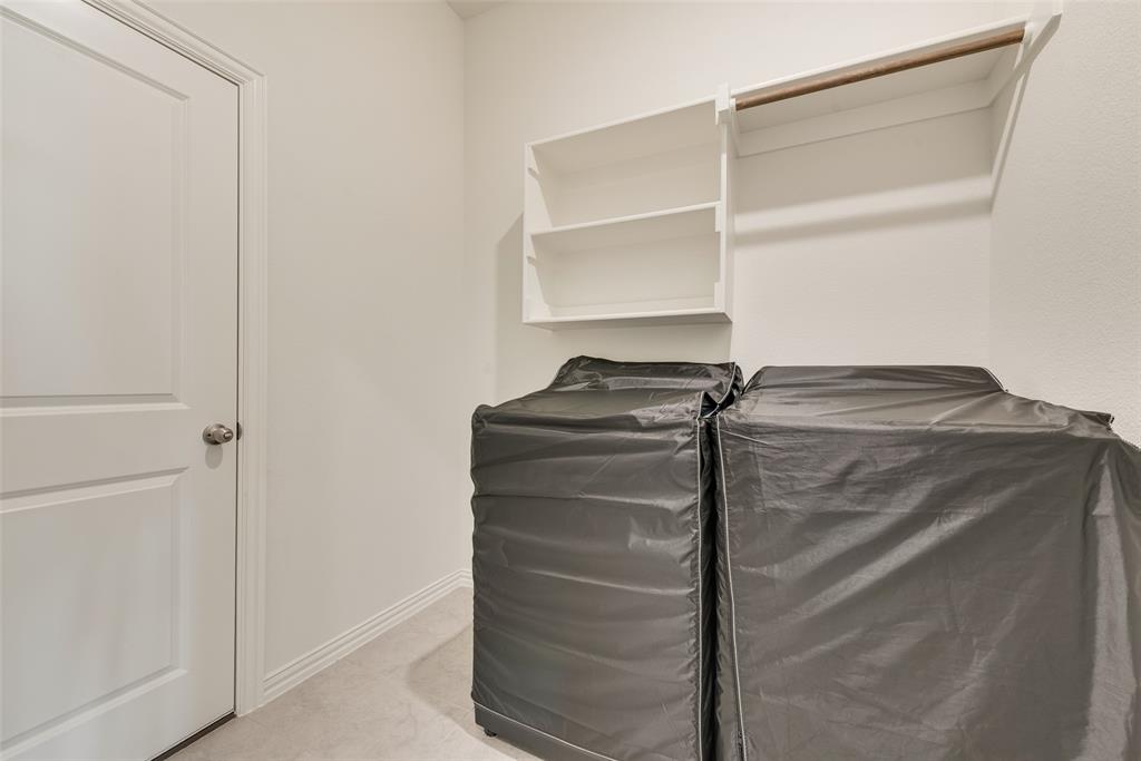 Utility room featuring wall-mounted open shelving, a built-in hanging rod, and a solid-core interior door