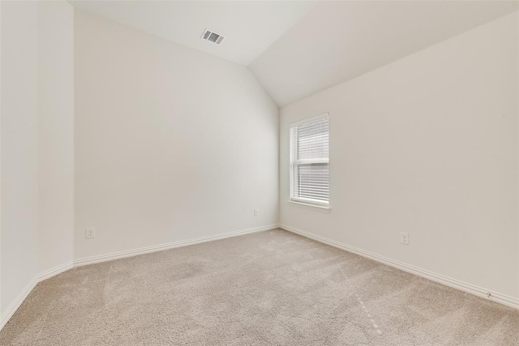 Neutral-toned room featuring a vaulted ceiling, wall-to-wall carpeting, and a single window with horizontal blinds