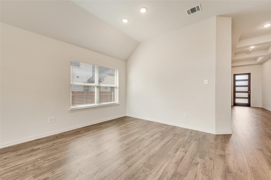 Interior space featuring vaulted ceilings, wood-finish flooring, recessed lighting, and a multi-panel exterior door with glass inserts