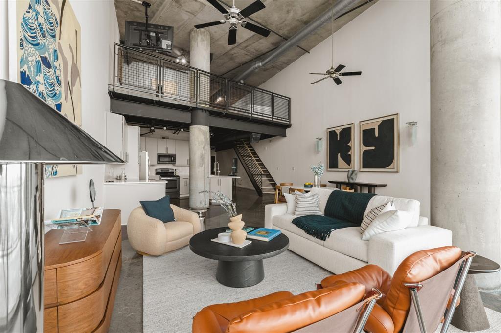 Vaulted ceiling, exposed concrete ceiling, industrial-style loft, mezzanine level, and open-concept living area