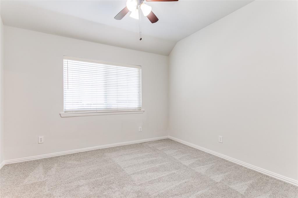 Neutral wall tones, carpeting, vaulted ceiling, ceiling fan with light fixture, and horizontal window blinds