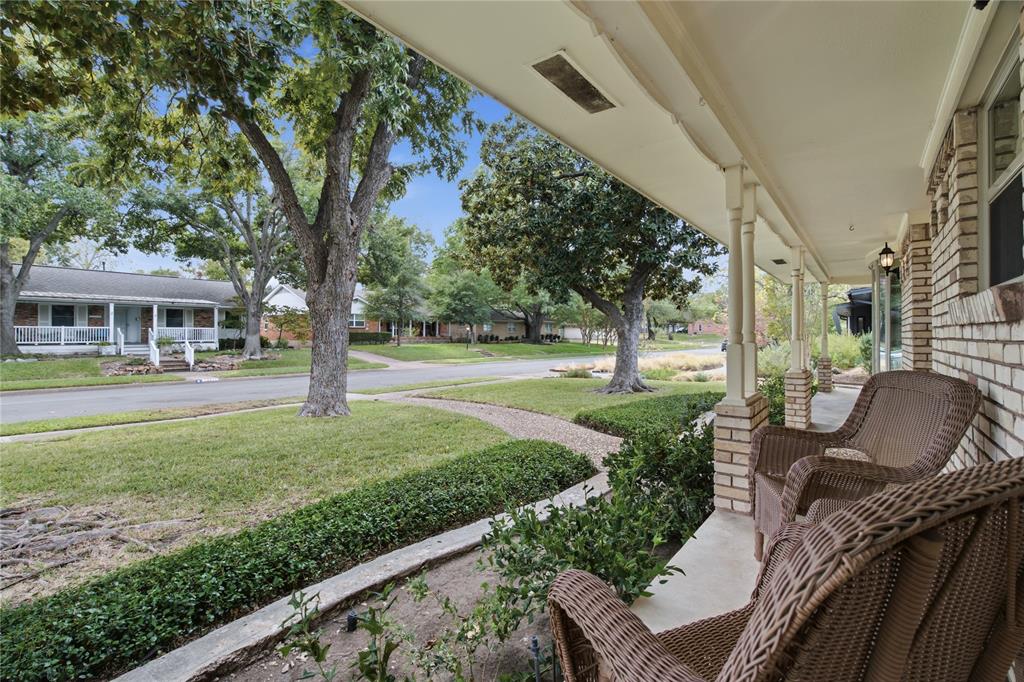 Covered front porch with brick column bases, concrete flooring, and exterior wall-mounted lighting Covered front porch with brick column bases, concrete flooring, and exterior wall-mounted lighting
