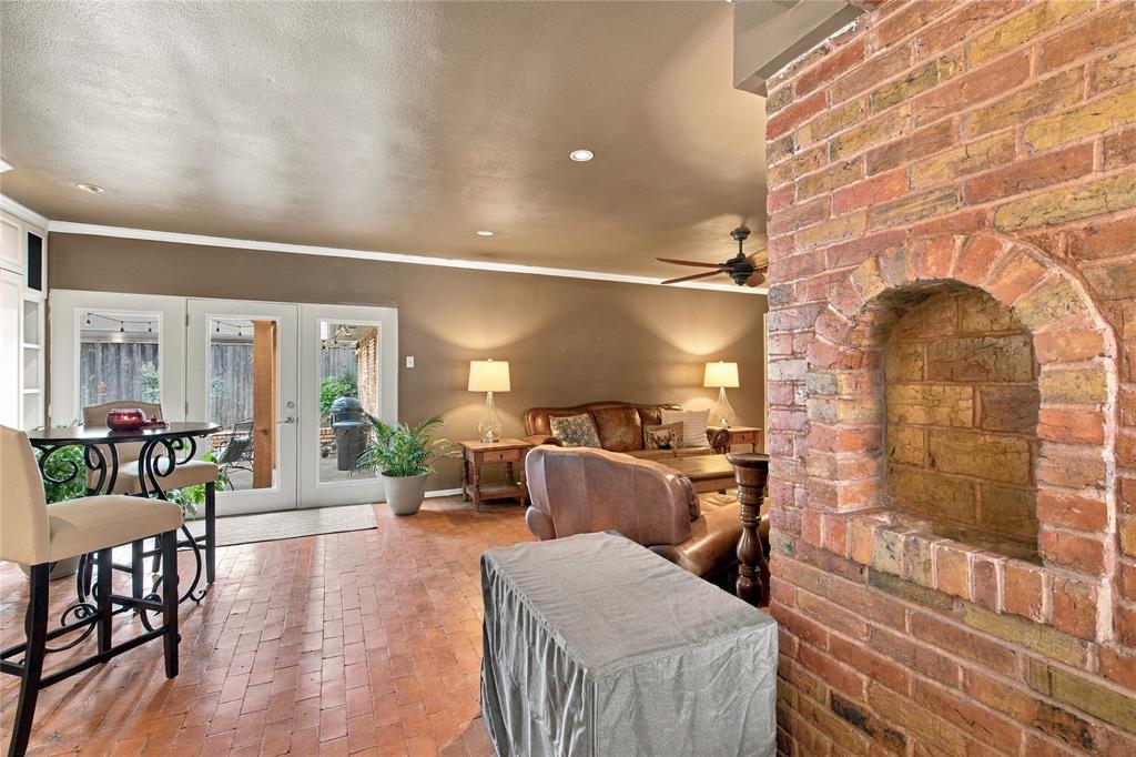 Exposed brick hearth featuring an arched alcove, tile flooring, and recessed ceiling lighting