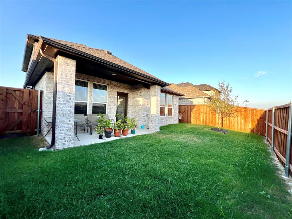 Rear view of house featuring a lawn and a patio area