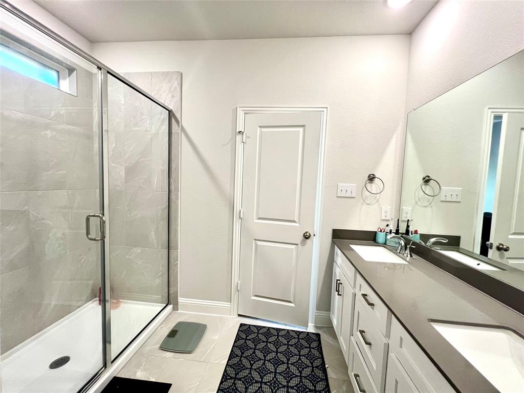 Bathroom featuring vanity, a shower with shower door, and tile patterned floors