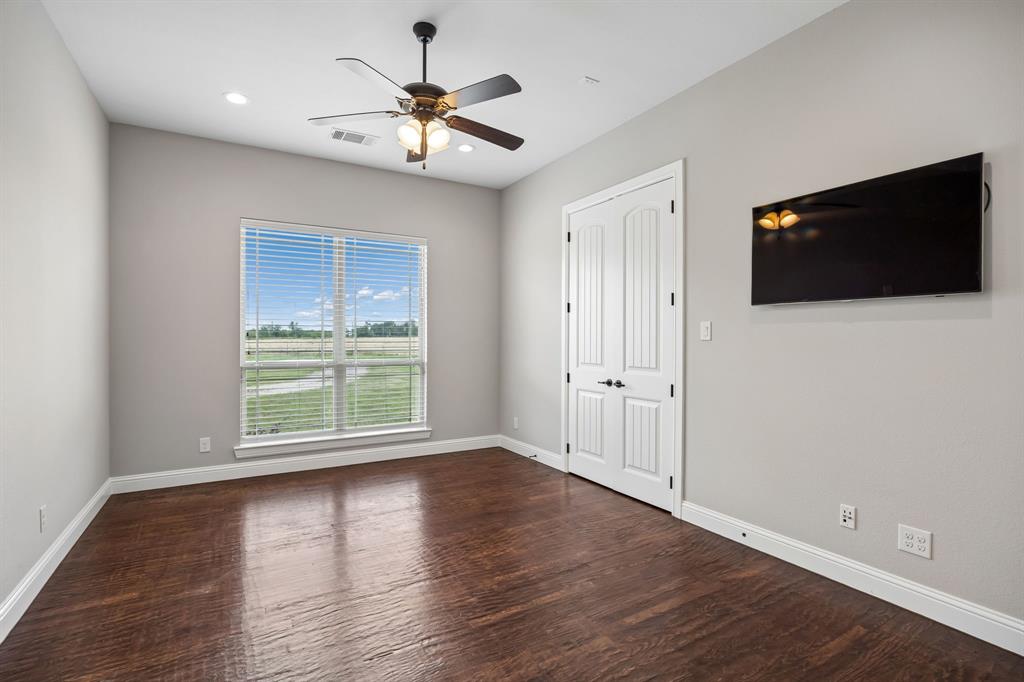 Room featuring wood-finish flooring, a ceiling fan with integrated lighting, recessed lighting, and double doors