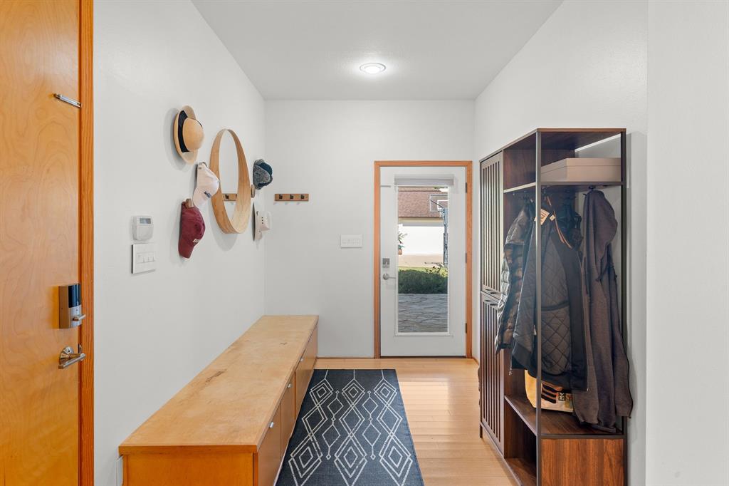 Entryway featuring a wood-finish entry door with smart lock technology, built-in natural wood bench cabinetry, recessed lighting, and a glass-panel exterior door