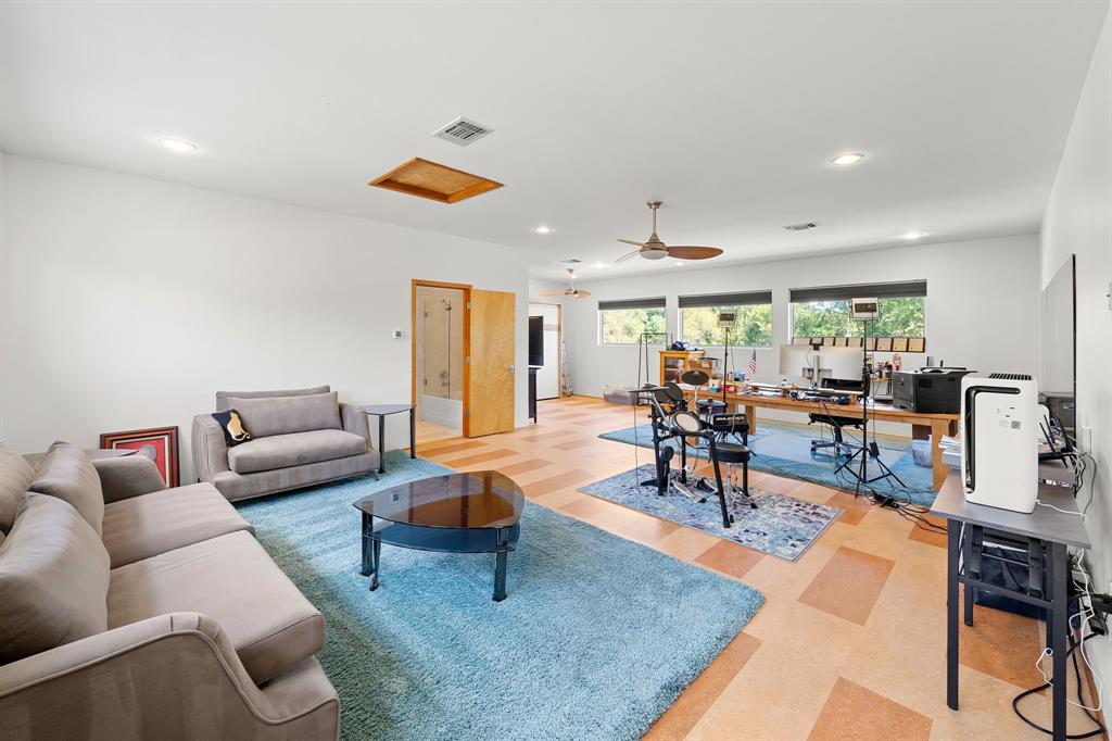 Spacious room featuring resilient tile flooring, recessed lighting, a ceiling fan with integrated light, and large horizontal windows