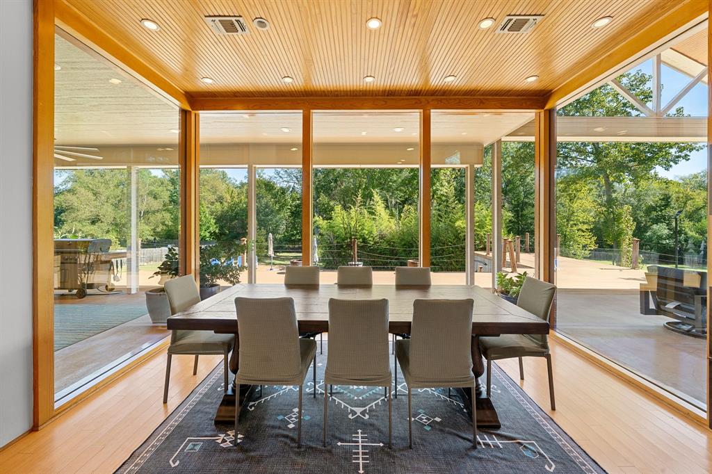 Floor-to-ceiling glass walls, wood-paneled ceiling, recessed lighting, and wood-finish flooring