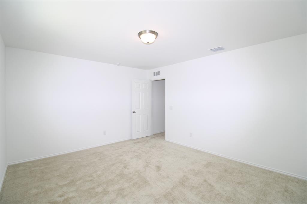 Neutral interior space featuring wall-to-wall carpeting, a six-panel door, and a flush-mount light fixture