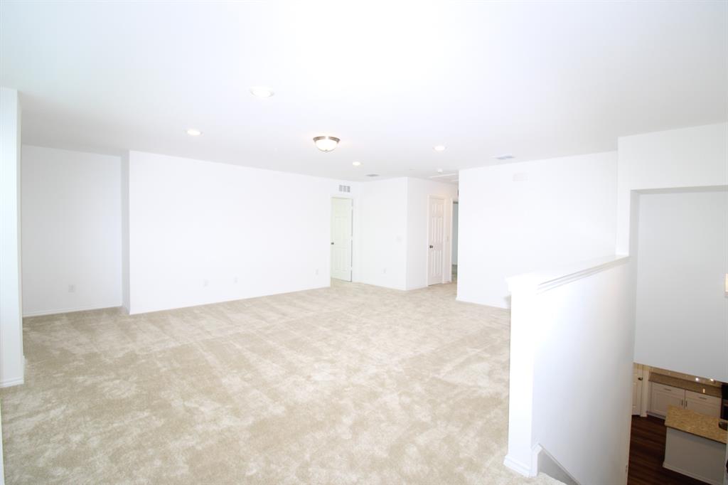 Expansive open-concept space featuring wall-to-wall carpeting, recessed ceiling lighting, and neutral paint finishes