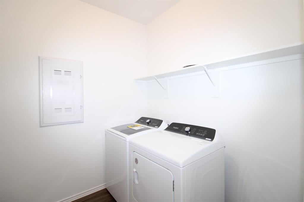 Dedicated laundry area featuring a wall-mounted shelving unit and an integrated electrical panel