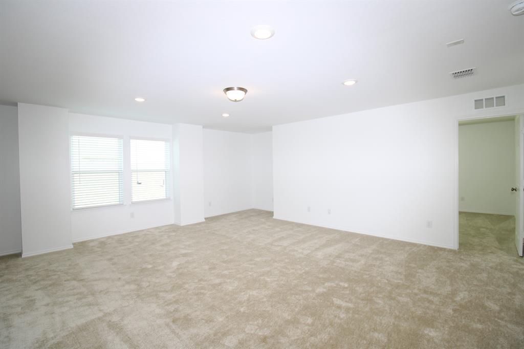 Interior space featuring neutral wall-to-wall carpeting, recessed lighting, a central flush-mount light fixture, and multiple windows with horizontal blinds