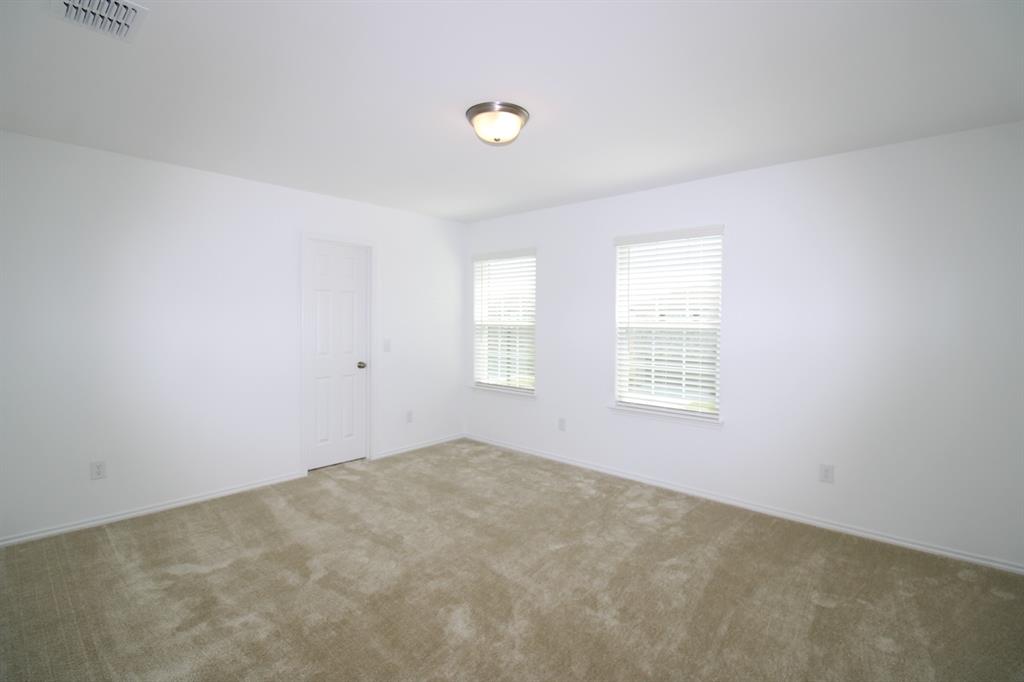Room with neutral carpeted flooring, white walls, dual windows with blinds, and a central flush-mount ceiling light fixture