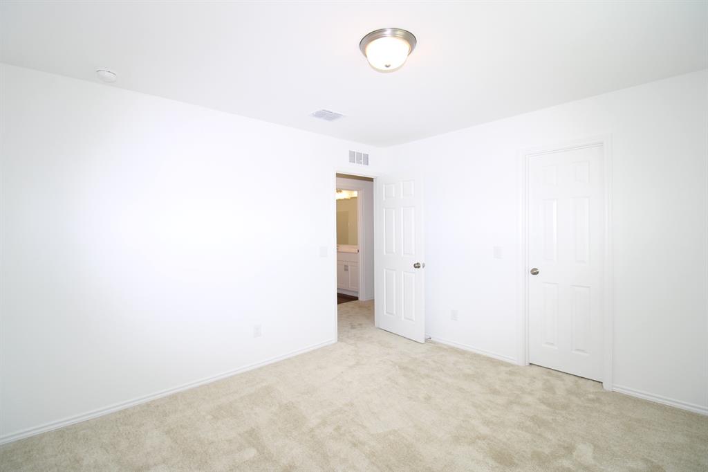 Neutral-toned wall-to-wall carpeting, six-panel interior doors, and a ceiling-mounted flush-mount light fixture