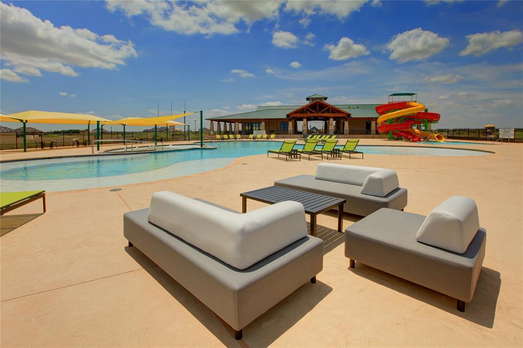 Expansive outdoor amenity area featuring a large swimming pool, multiple water slides, and dedicated lounge seating