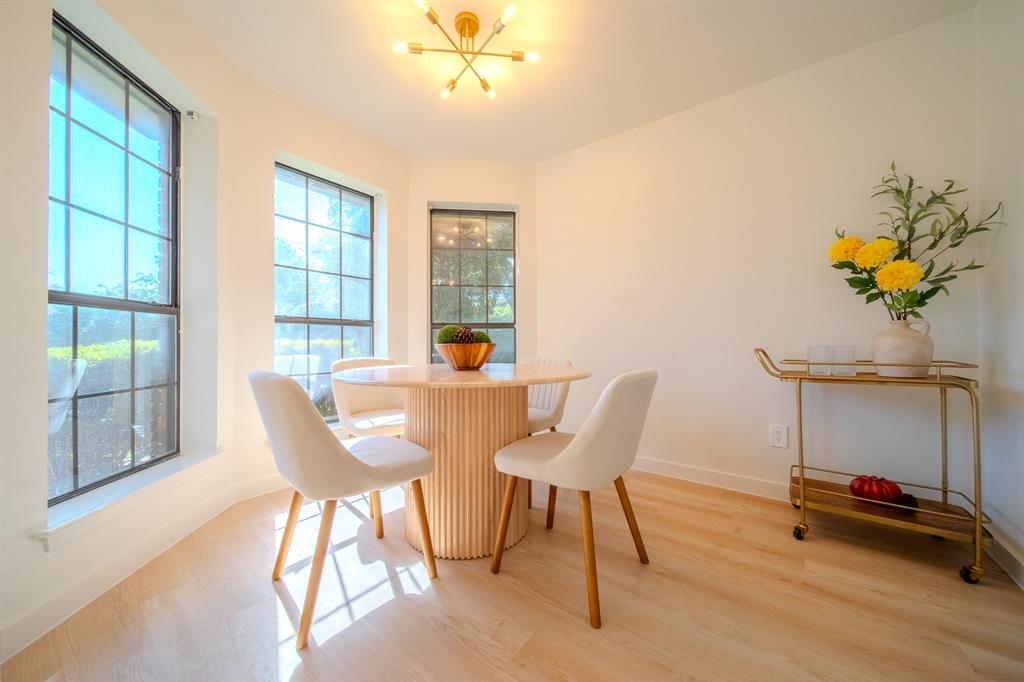 Sun-filled alcove featuring large windows, wood-finish flooring, and a modern multi-arm light fixture