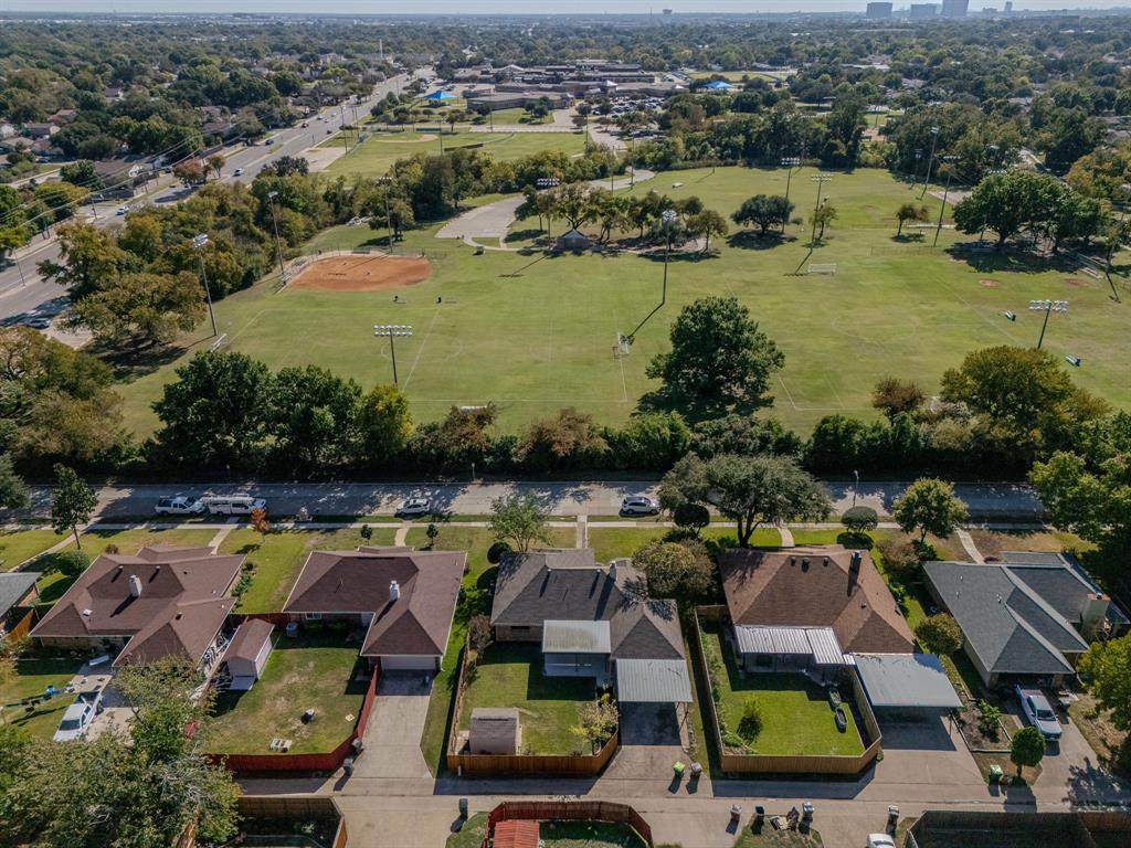 Aerial perspective of residential properties featuring shingle roofing, attached garages, and fenced rear yards