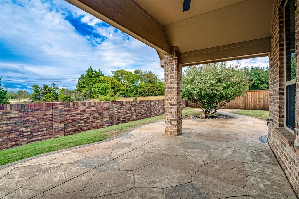 Gorgeous covered patio just off of living room with stamped concrete back patio which extends to fire pit area