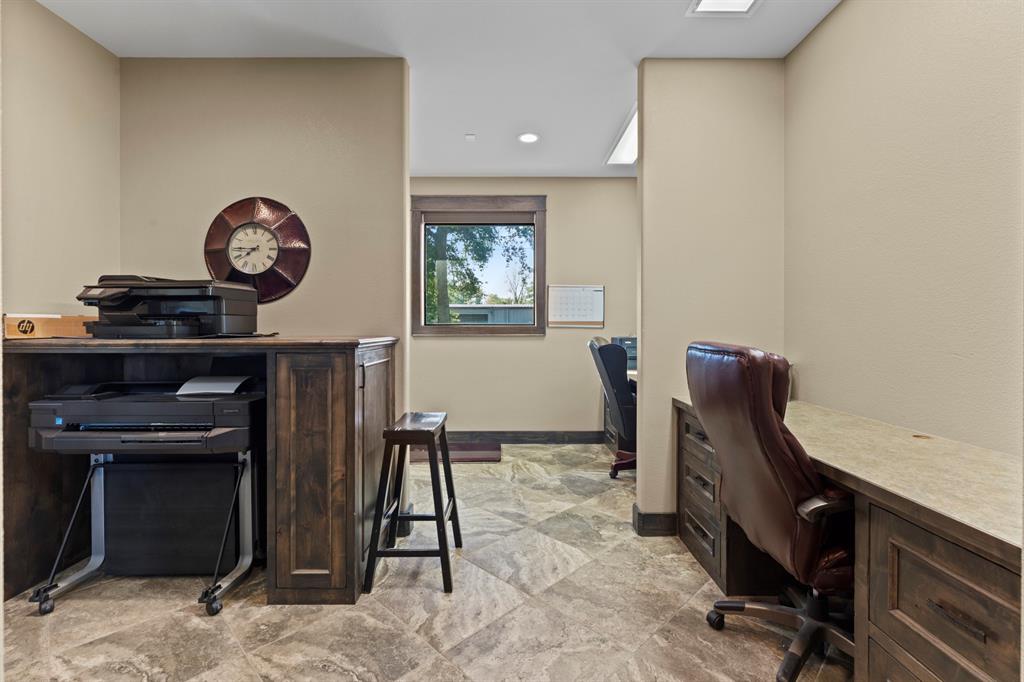 Built-in wooden cabinetry, stone-finish tile flooring, and integrated desk workspace featuring countertop surface