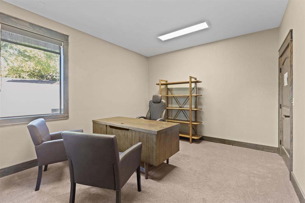 Neutral-toned room featuring wall-to-wall carpeting, wood-finish window casing and door frame, and a rectangular ceiling-mounted light fixture