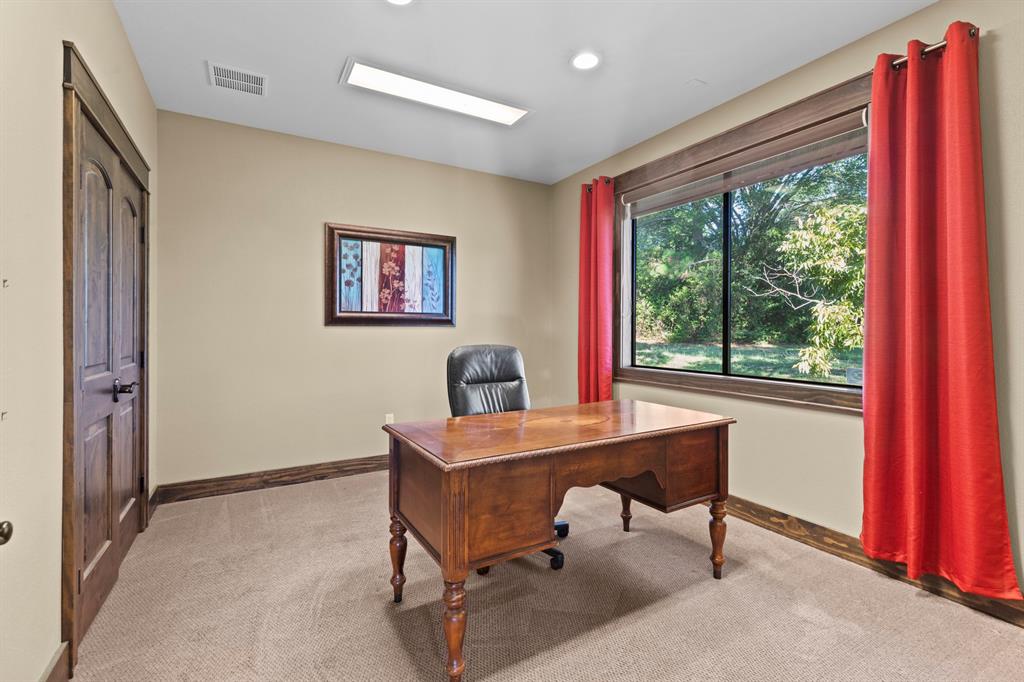 Room featuring wood-trim accents, flush-mount lighting, and a window with exterior greenery