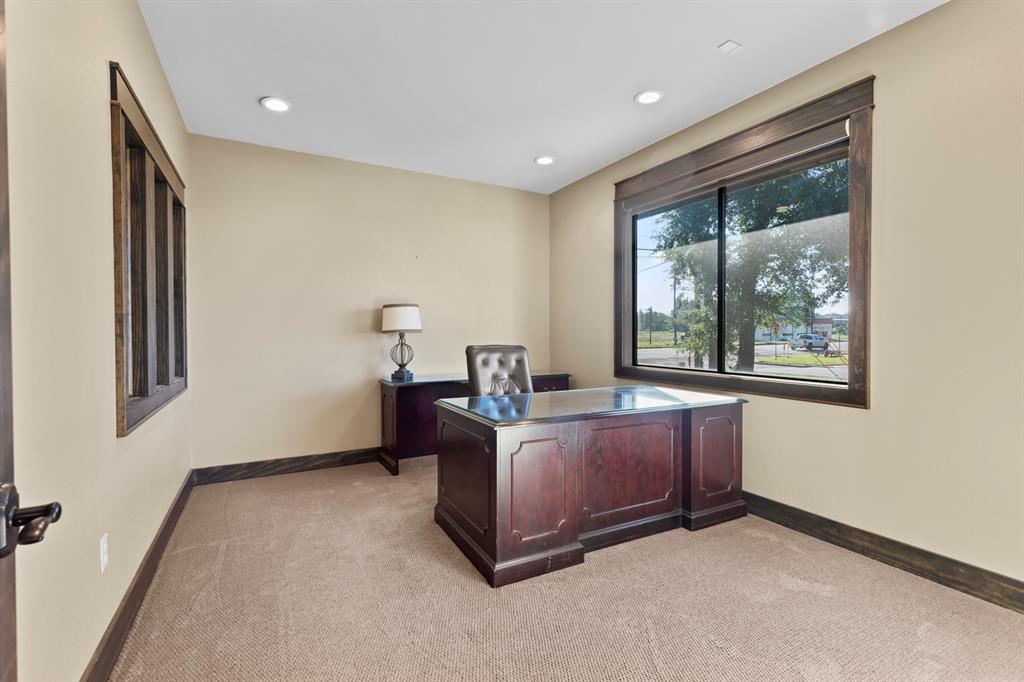 Room featuring neutral wall tones, plush carpeting, recessed lighting, and large windows framed in dark-stained wood trim