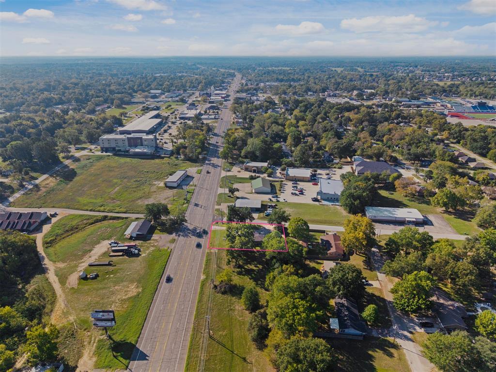 Aerial perspective of a parcel featuring direct street frontage, mature trees, and established landscape