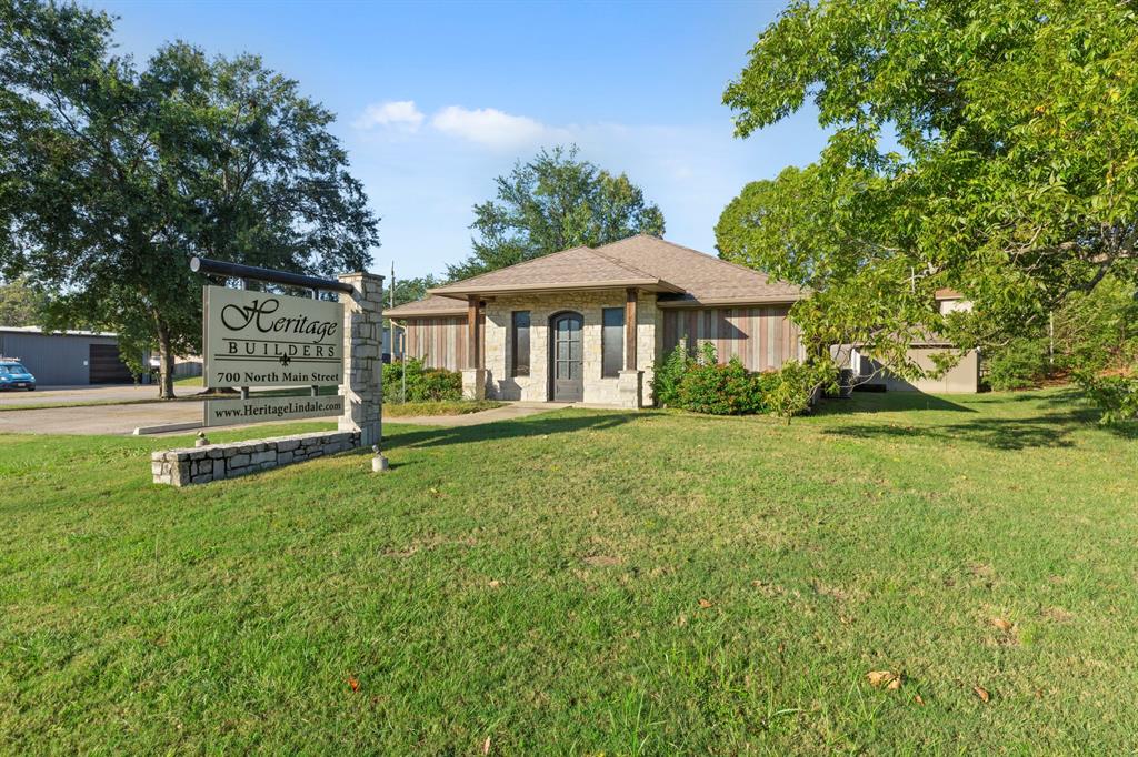 Single-story exterior featuring stone masonry, vertical wood siding, a hip roof, and decorative timber-frame porch accents