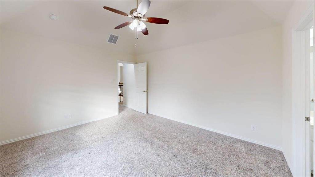 Vaulted ceilings with a multi-blade ceiling fan, neutral wall tones, and carpeted flooring
