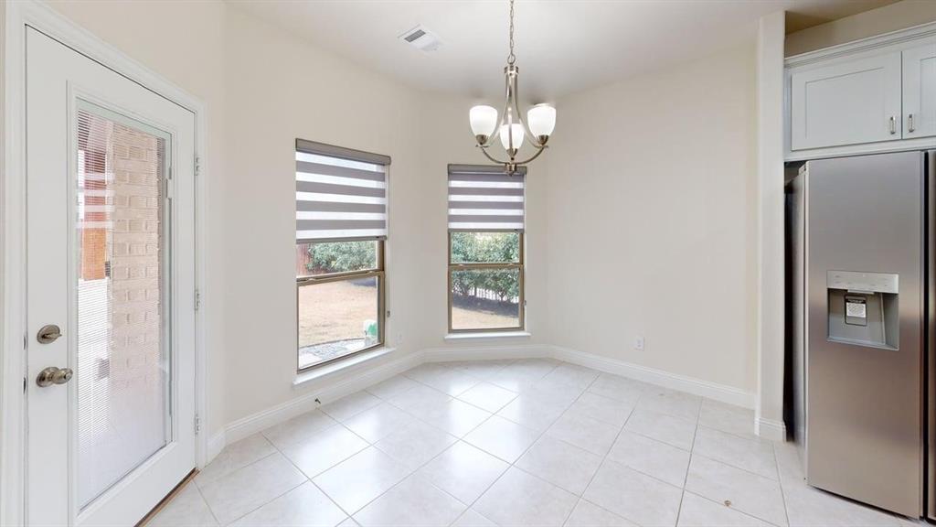 Ceramic tile flooring, neutral wall tones, multi-light chandelier, and large windows with integrated blinds