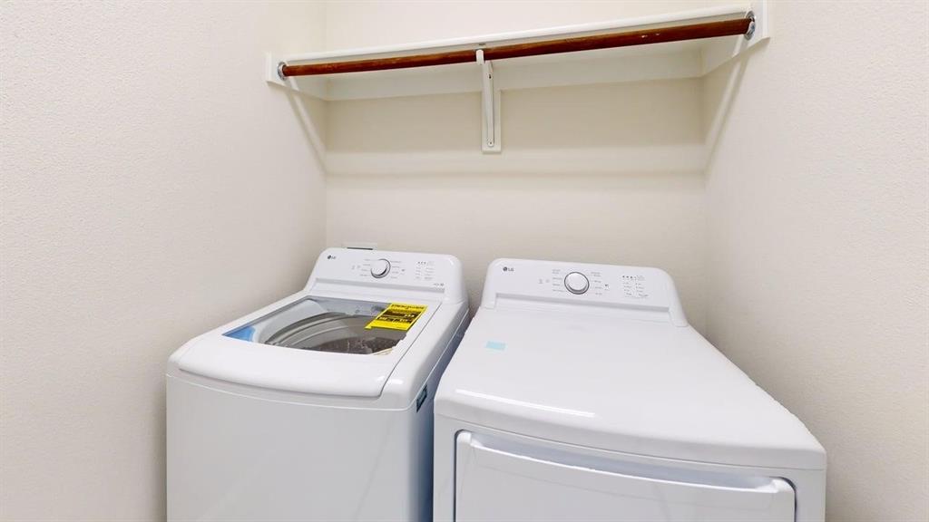 Dedicated laundry area featuring a built-in wooden hanging rod and overhead white shelving